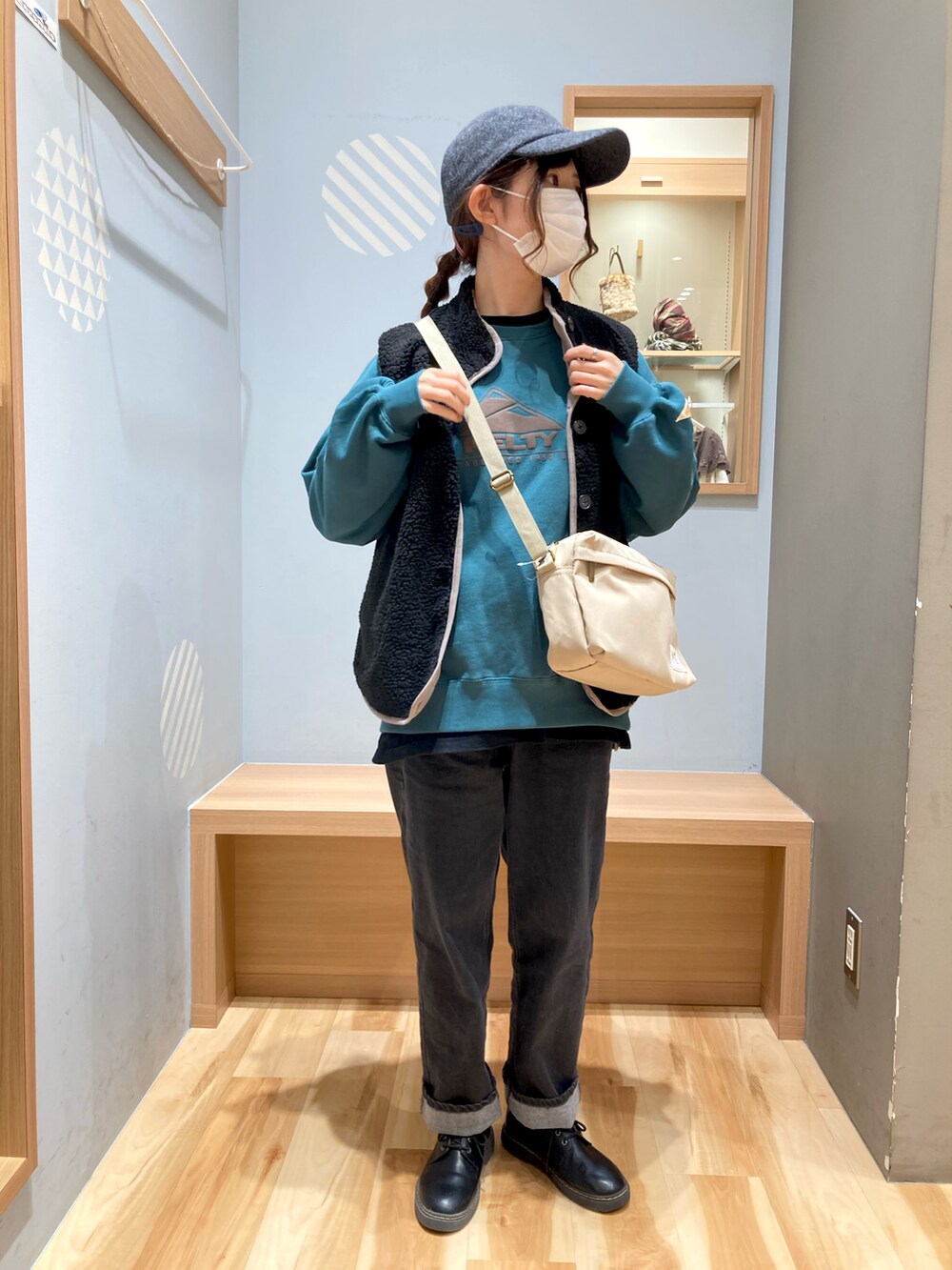 ベージュ系のバッグ、ブラック系のベスト、ブラック系のデニムパンツを着用したレディースの秋コーディネートの2枚目の写真