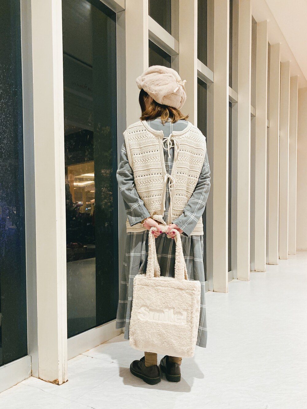 ホワイト系のトートバッグ、ベージュ系のベスト、グレー系のワンピース/ドレスを着用したレディースの秋コーディネートの3枚目の写真