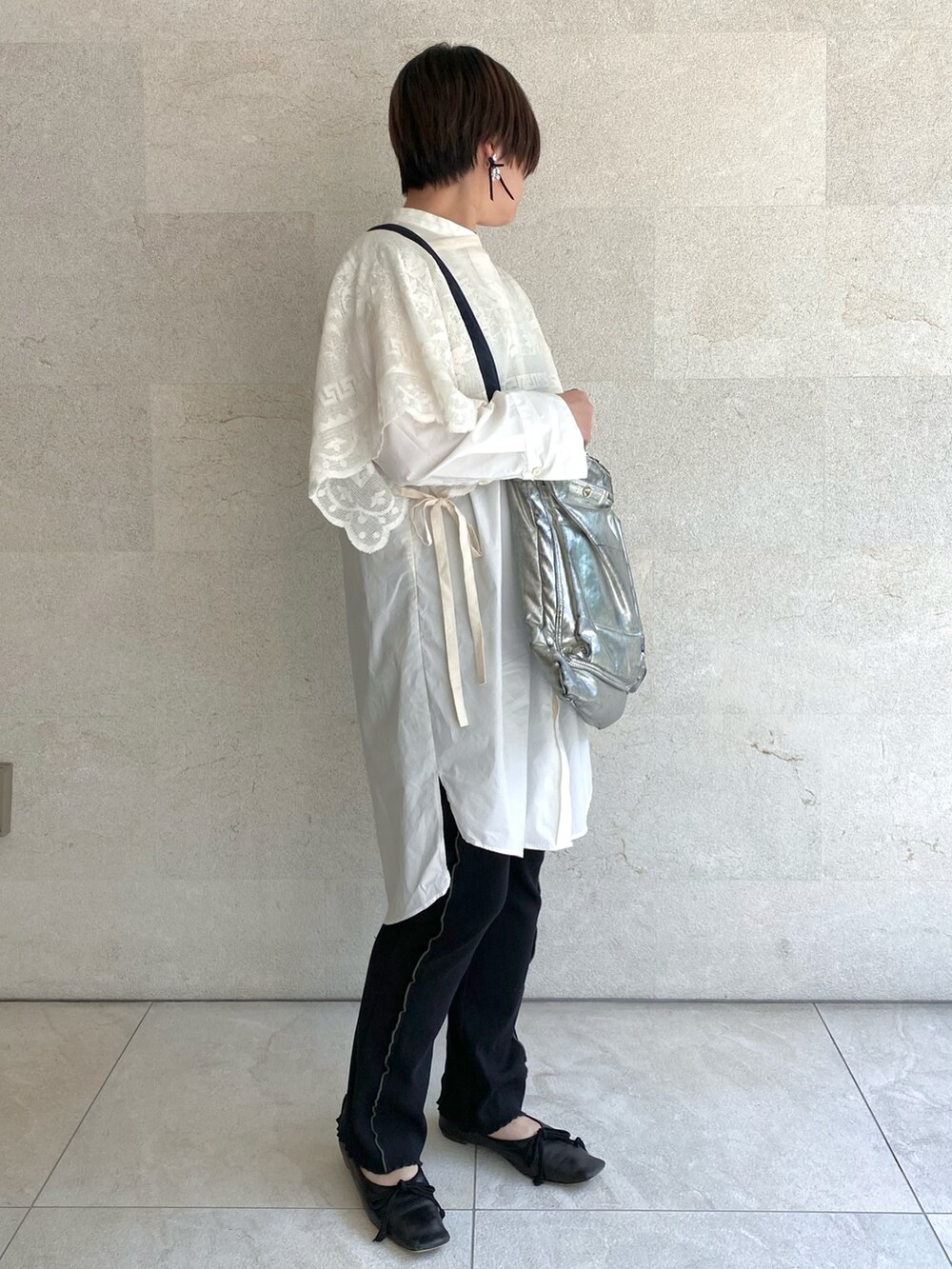 シルバー系のショルダーバッグ、ホワイト系のその他トップス、ブラック系のその他パンツを着用したレディースの春コーディネートの2枚目の写真