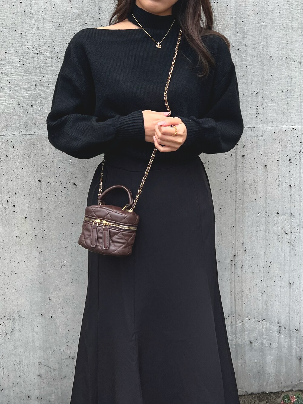 ブラック系のニット/セーター、ブラウン系のショルダーバッグを着用したレディースの冬コーディネートの3枚目の写真