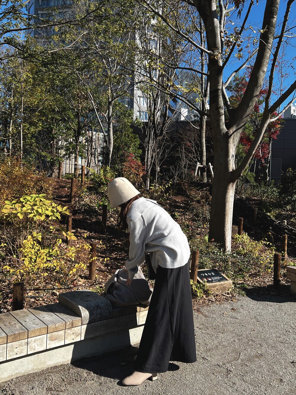 グレー系のニット/セーター、ブラック系のショルダーバッグ、ベージュ系のハットを着用したレディースの冬コーディネートの2枚目の写真