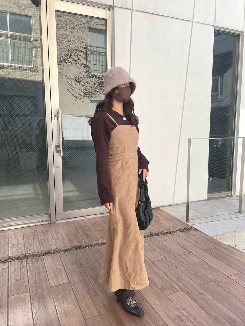 ベージュ系のワンピース、ブラウン系のニット/セーター、ベージュ系のハットを着用したレディースの冬コーディネートの2枚目の写真