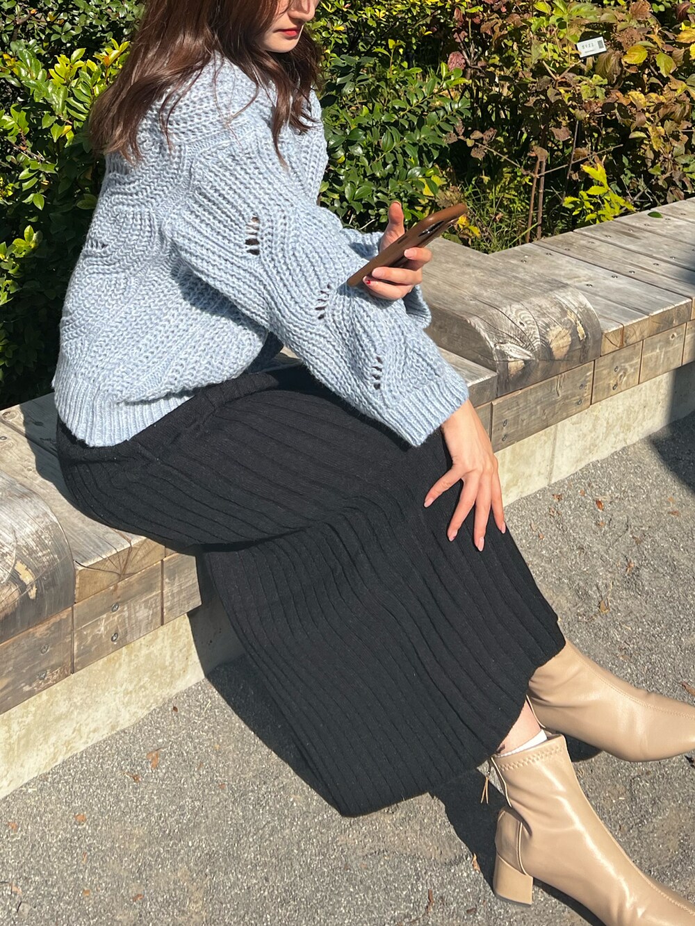 ブラック系のスカート、ブルー系のニット/セーター、ベージュ系のシューズを着用したレディースの秋コーディネートの4枚目の写真