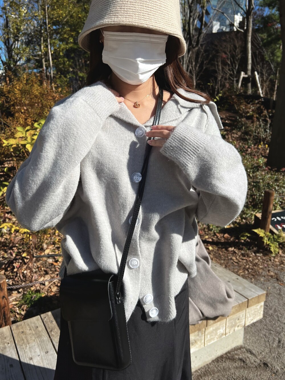 グレー系のニット/セーター、ブラック系のショルダーバッグ、ベージュ系のハットを着用したレディースの冬コーディネートの3枚目の写真