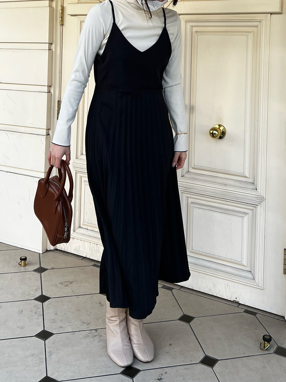 ブラウン系のボストンバッグ、ブルー系のワンピース、ホワイト系のニット/セーターを着用したレディースの春コーディネートの2枚目の写真