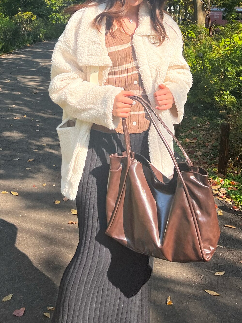 ホワイト系のムートンコート、ベージュ系のジャケット/アウター、ブラック系のスカートを着用したレディースの秋コーディネートの3枚目の写真