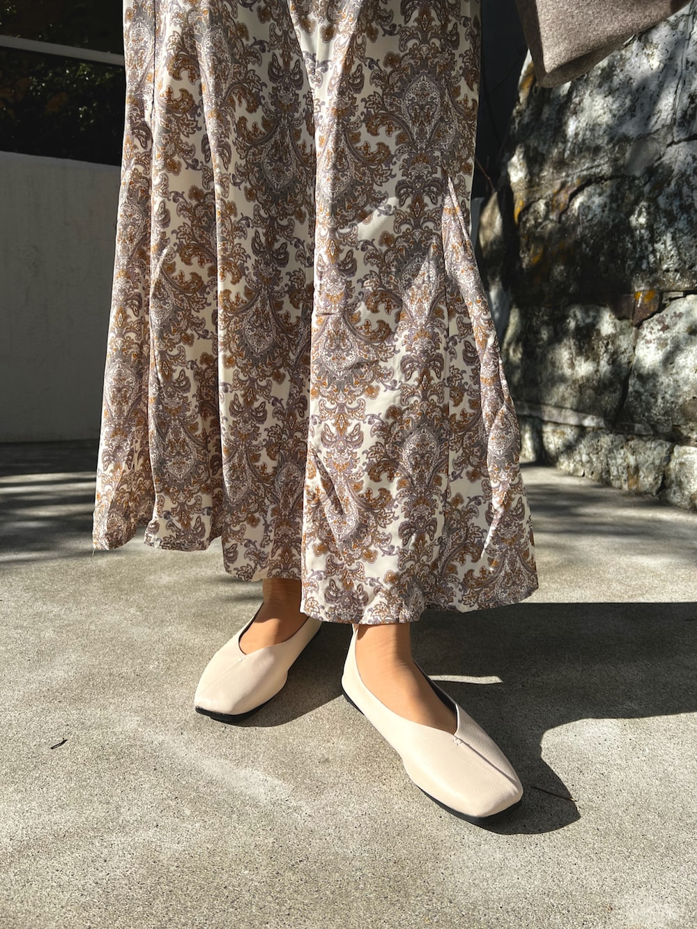 ブラウン系のパンプス、ホワイト系のスカートを着用したレディースの春コーディネートの4枚目の写真