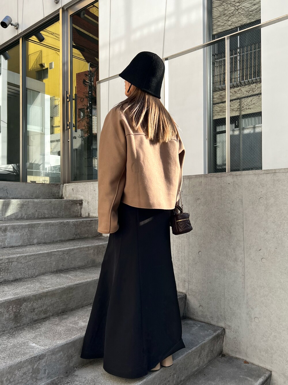 ブラウン系のテーラードジャケット、ベージュ系のハットを着用したレディースの春コーディネートの2枚目の写真