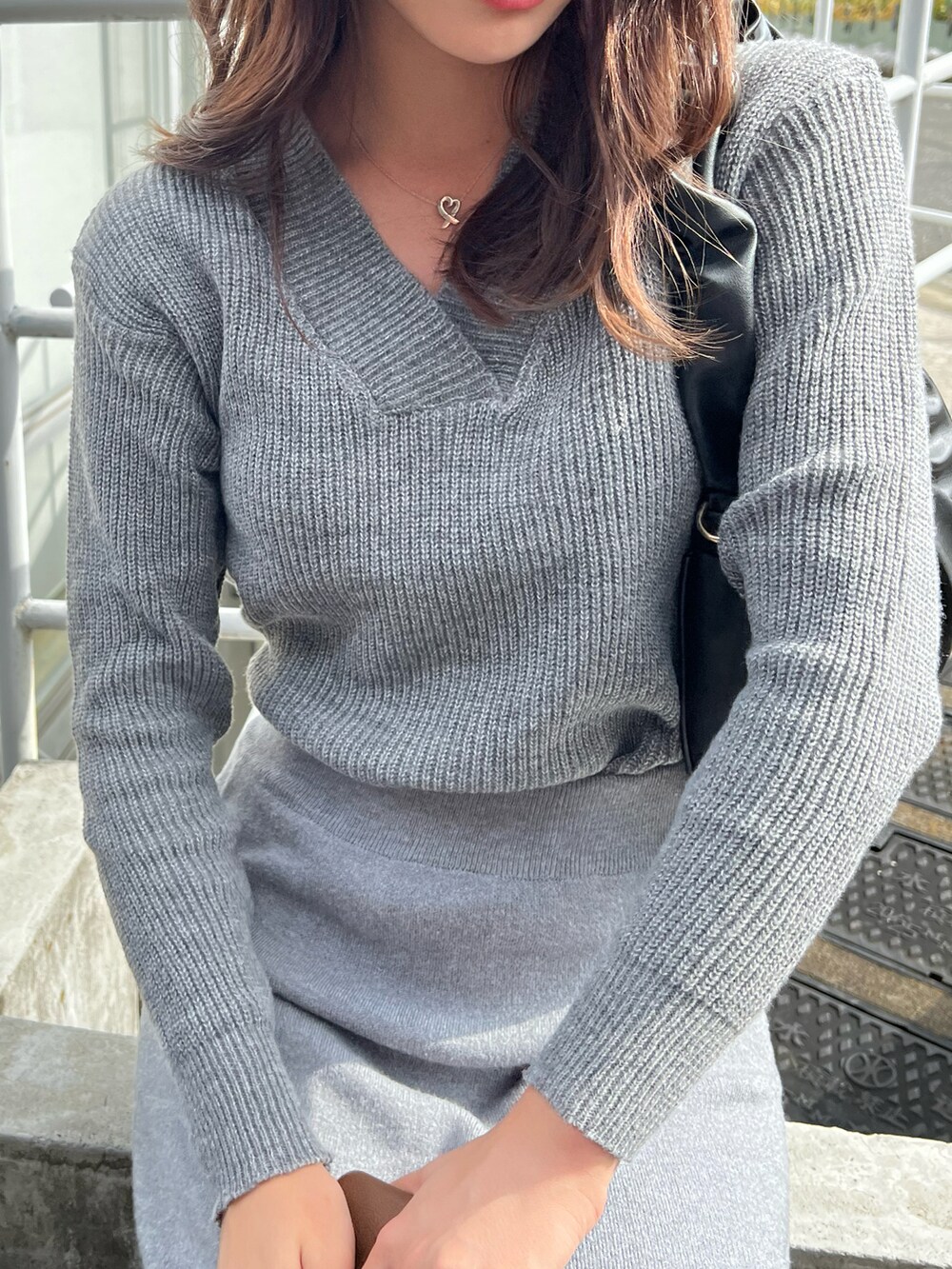 グレー系のニット/セーター、グレー系のスカート、ブラック系のハンドバッグを着用したレディースの冬コーディネートの2枚目の写真