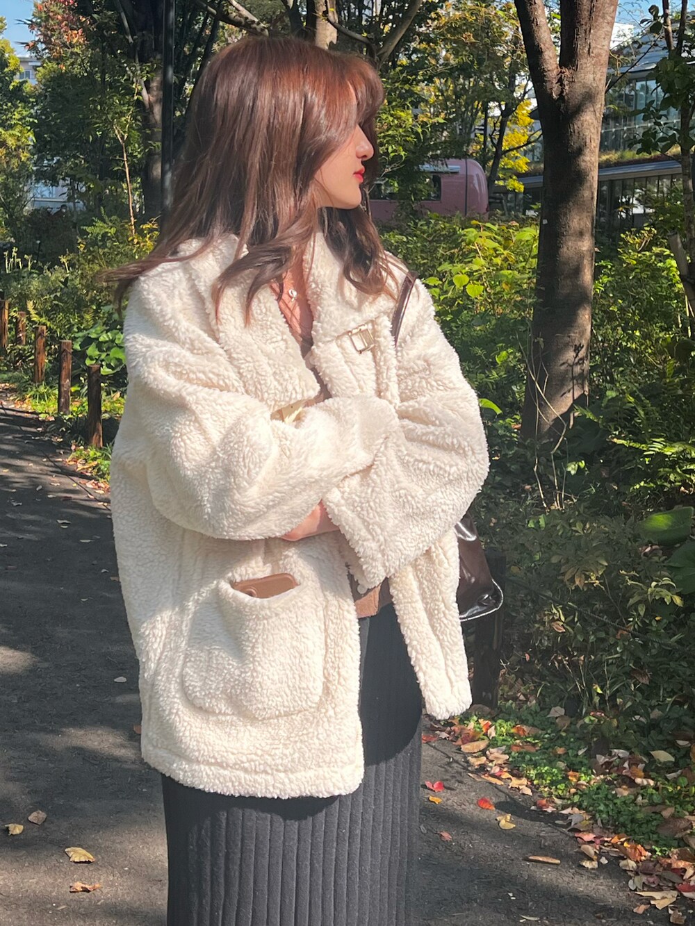 ホワイト系のムートンコート、ベージュ系のジャケット/アウター、ブラック系のスカートを着用したレディースの秋コーディネートの2枚目の写真