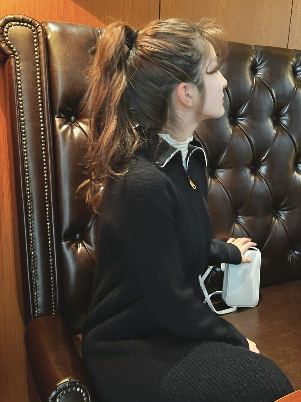 ブラック系のワンピース、ホワイト系のショルダーバッグを着用したレディースの冬コーディネートの2枚目の写真