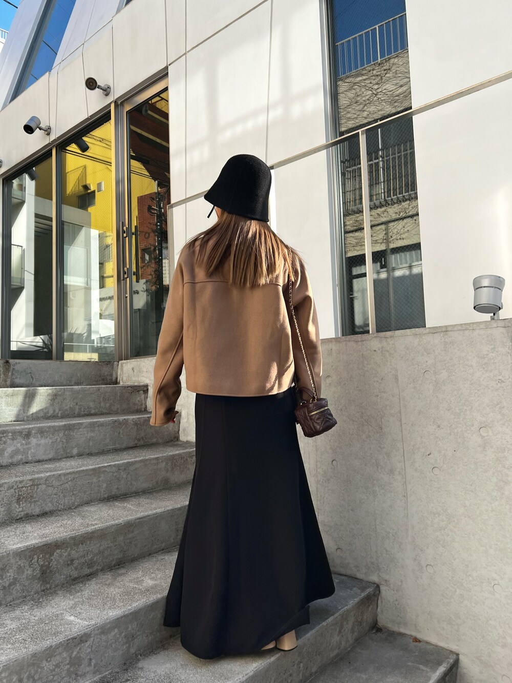 ブラウン系のテーラードジャケット、ブラウン系のショルダーバッグを着用したレディースの冬コーディネートの2枚目の写真