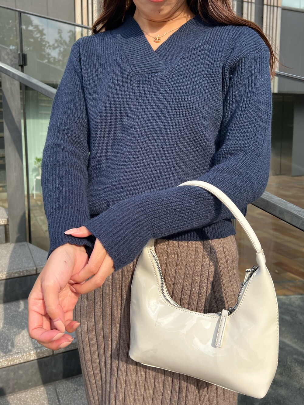 ベージュ系のスカート、ブルー系のニット/セーターを着用したレディースの冬コーディネートの3枚目の写真