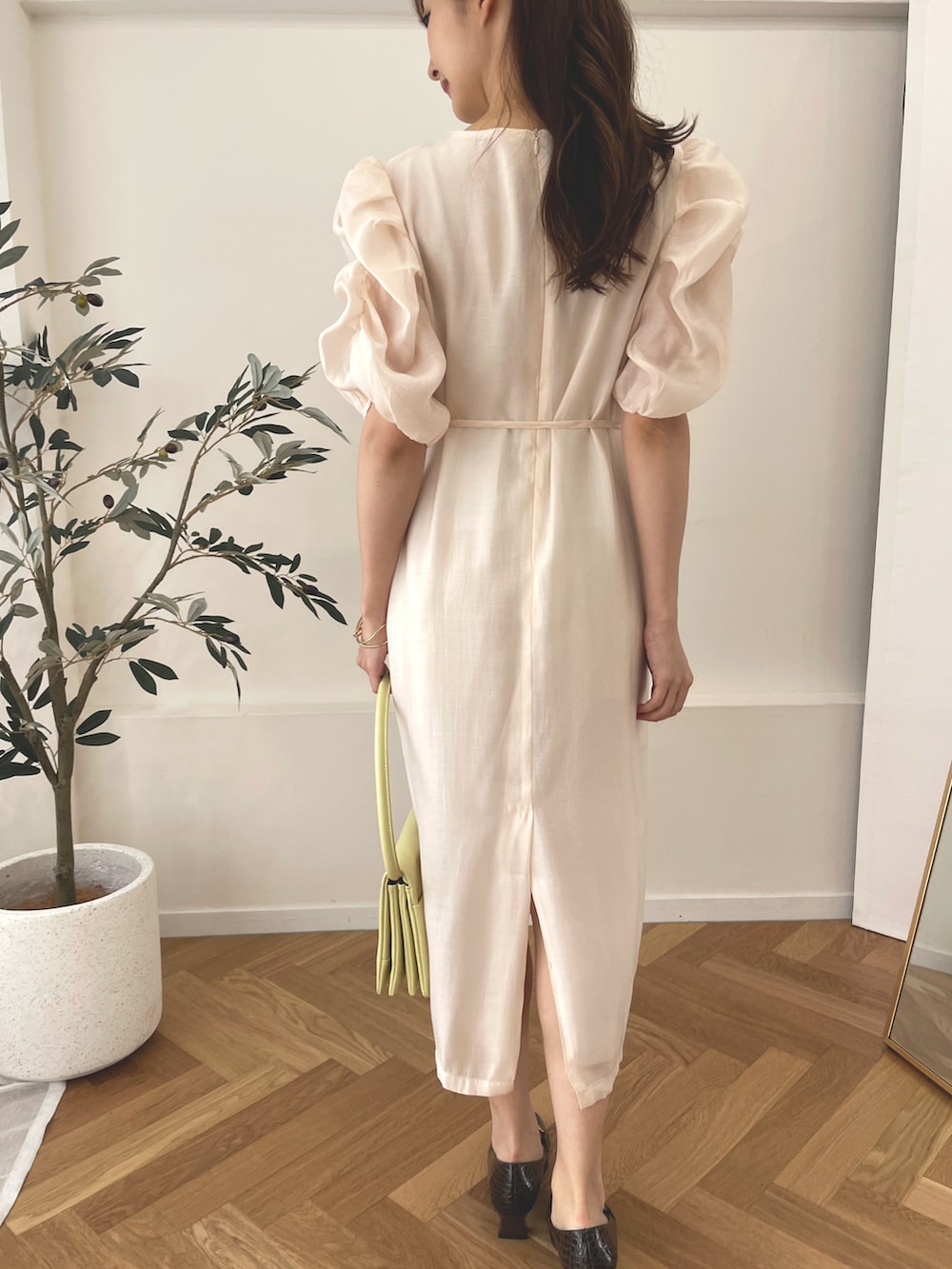 ブラウン系のローファー、イエロー系のハンドバッグ、ホワイト系のワンピースを着用したレディースの夏コーディネートの2枚目の写真