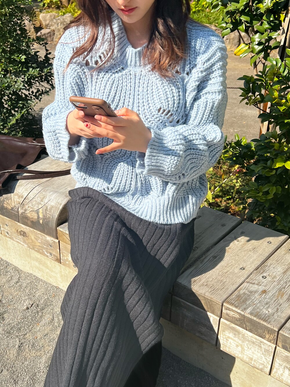 ブラック系のスカート、ブルー系のニット/セーター、ベージュ系のシューズを着用したレディースの秋コーディネートの3枚目の写真