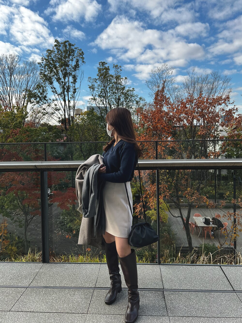 ブルー系のニット/セーター、ベージュ系のスカート、ブラック系のショルダーバッグを着用したレディースの冬コーディネートの3枚目の写真