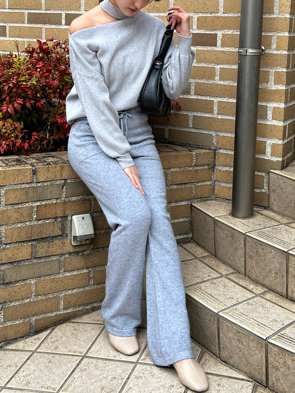 グレー系のニット/セーター、グレー系のセットアップを着用したレディースの冬コーディネートの3枚目の写真