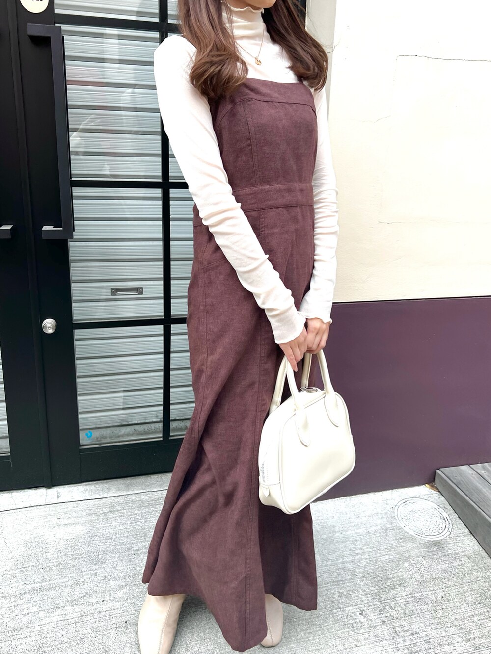 ホワイト系のボストンバッグ、ブラウン系のワンピースを着用したレディースの春コーディネートの2枚目の写真