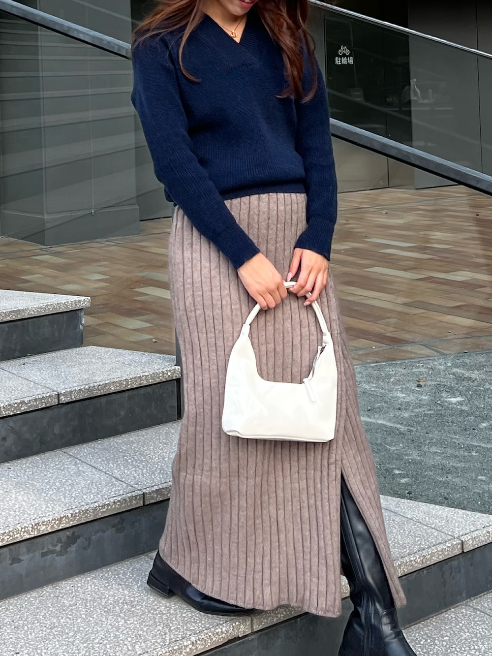 ベージュ系のスカート、ブルー系のニット/セーターを着用したレディースの冬コーディネートの2枚目の写真