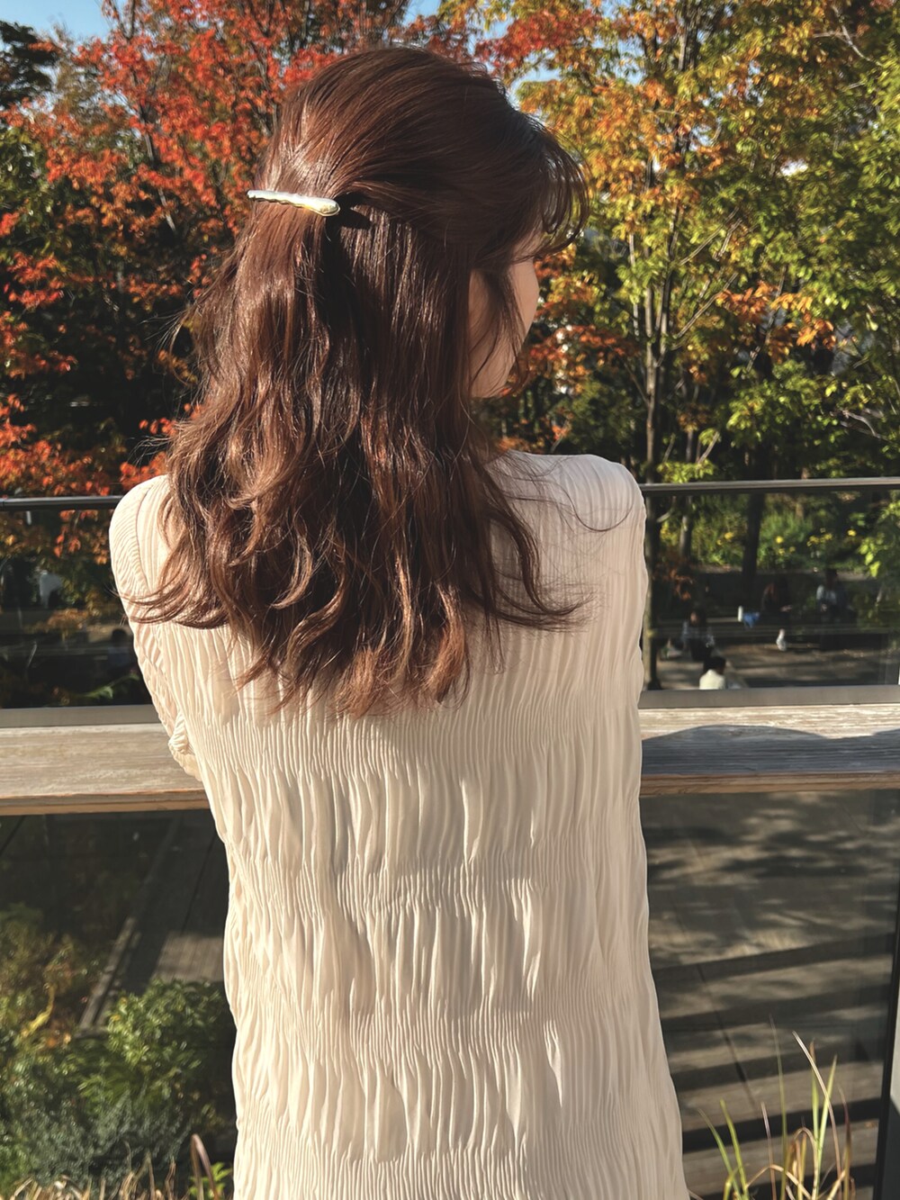 ホワイト系のワンピース、ブラウン系のショルダーバッグ、ベージュ系のブーツを着用したレディースの冬コーディネートの2枚目の写真