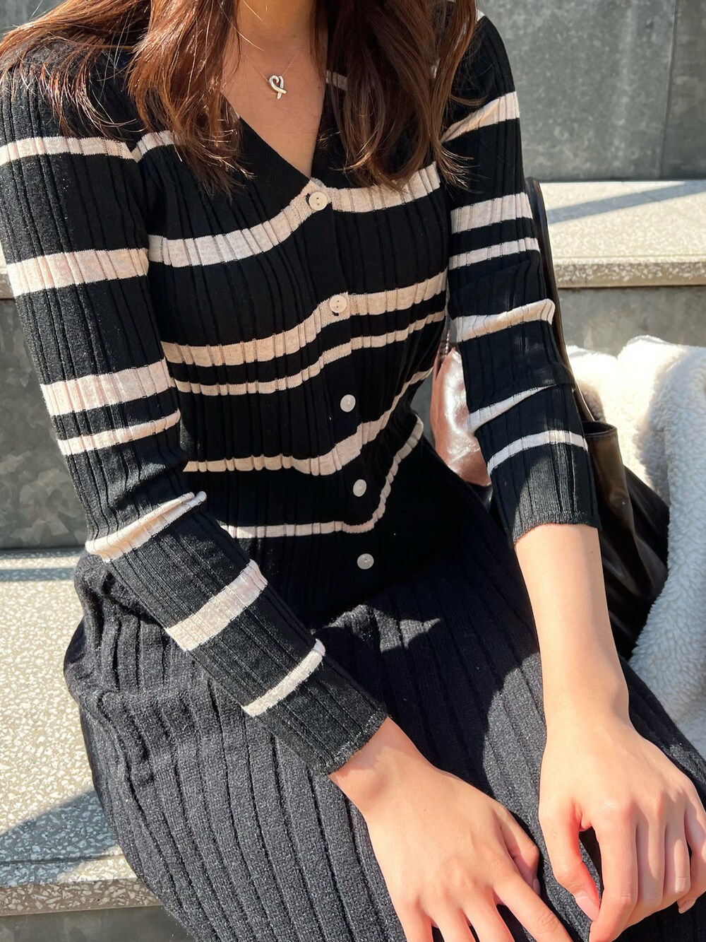 ブラック系のスカート、ブラック系のニット/セーターを着用したレディースの冬コーディネートの2枚目の写真