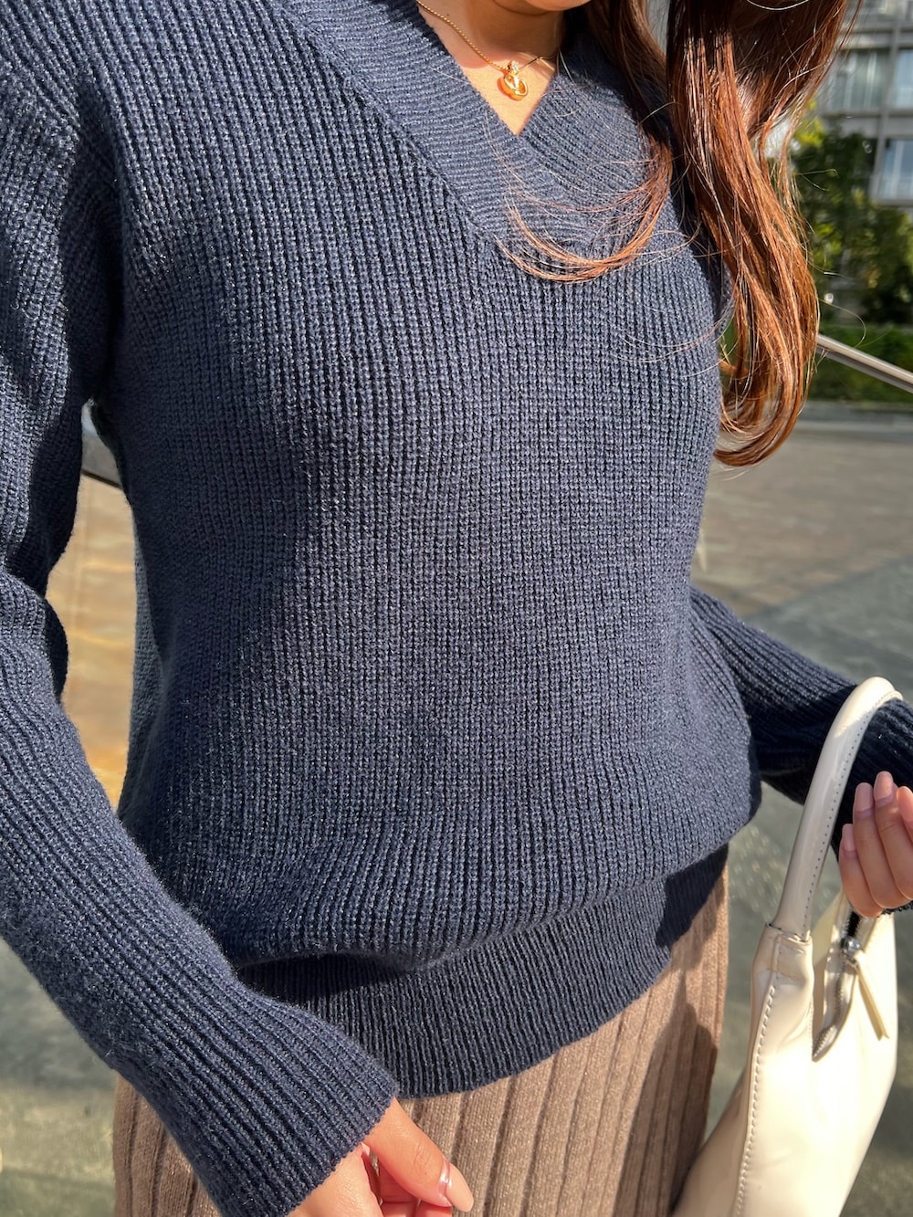 ベージュ系のスカート、ブルー系のニット/セーターを着用したレディースの冬コーディネートの4枚目の写真