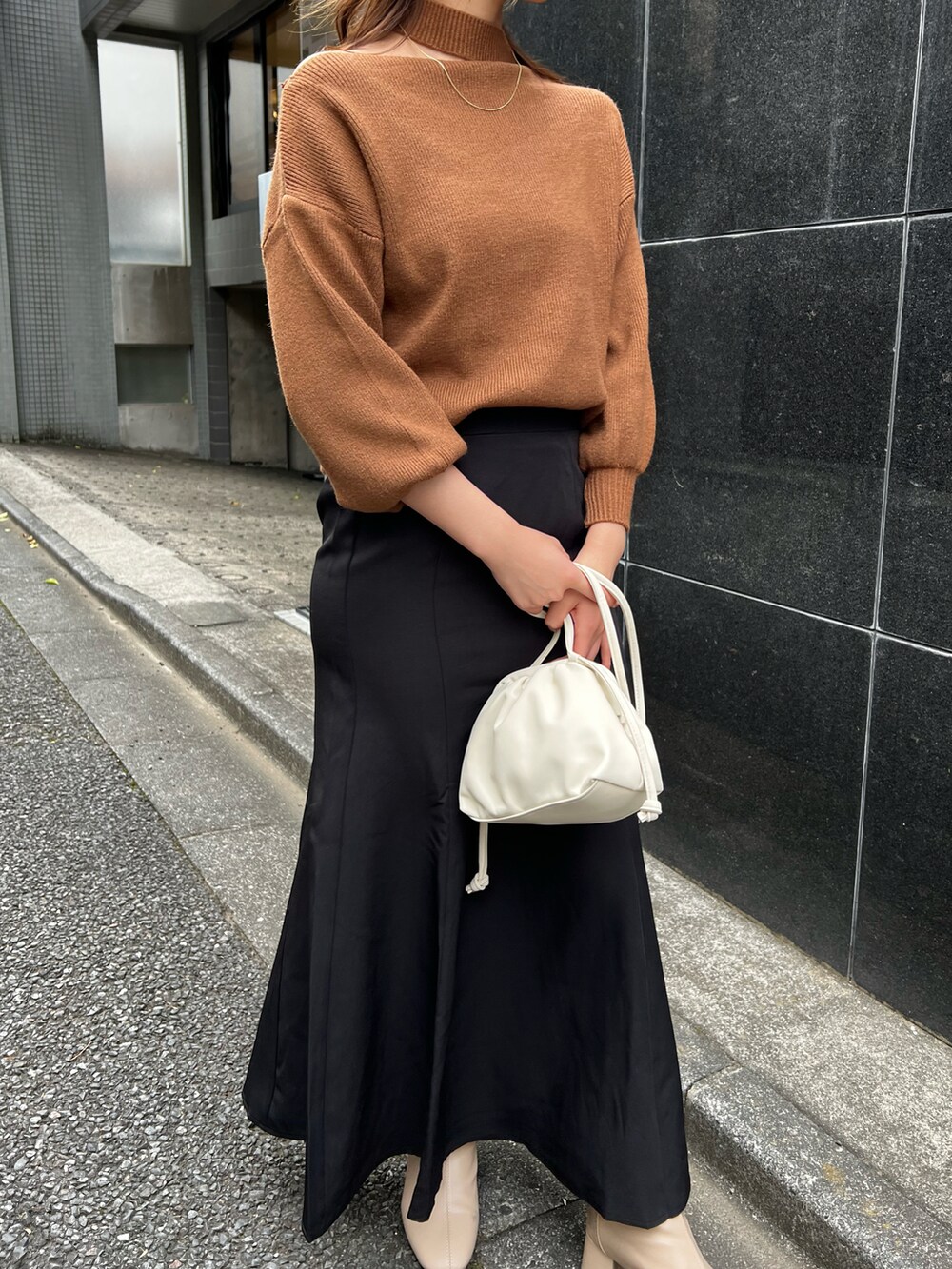 ブラウン系のニット/セーターを着用したレディースの冬コーディネートの2枚目の写真