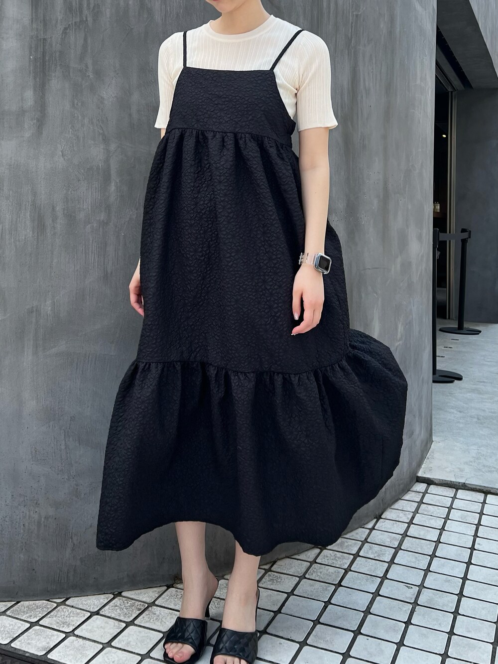 ブラック系のワンピースを着用したレディースの春コーディネートの2枚目の写真