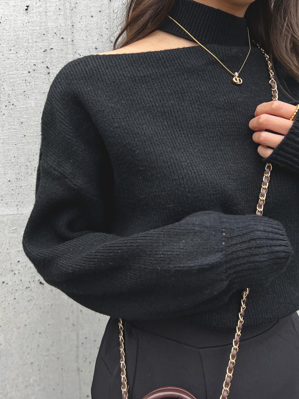 ブラック系のニット/セーター、ブラウン系のショルダーバッグを着用したレディースの冬コーディネートの2枚目の写真