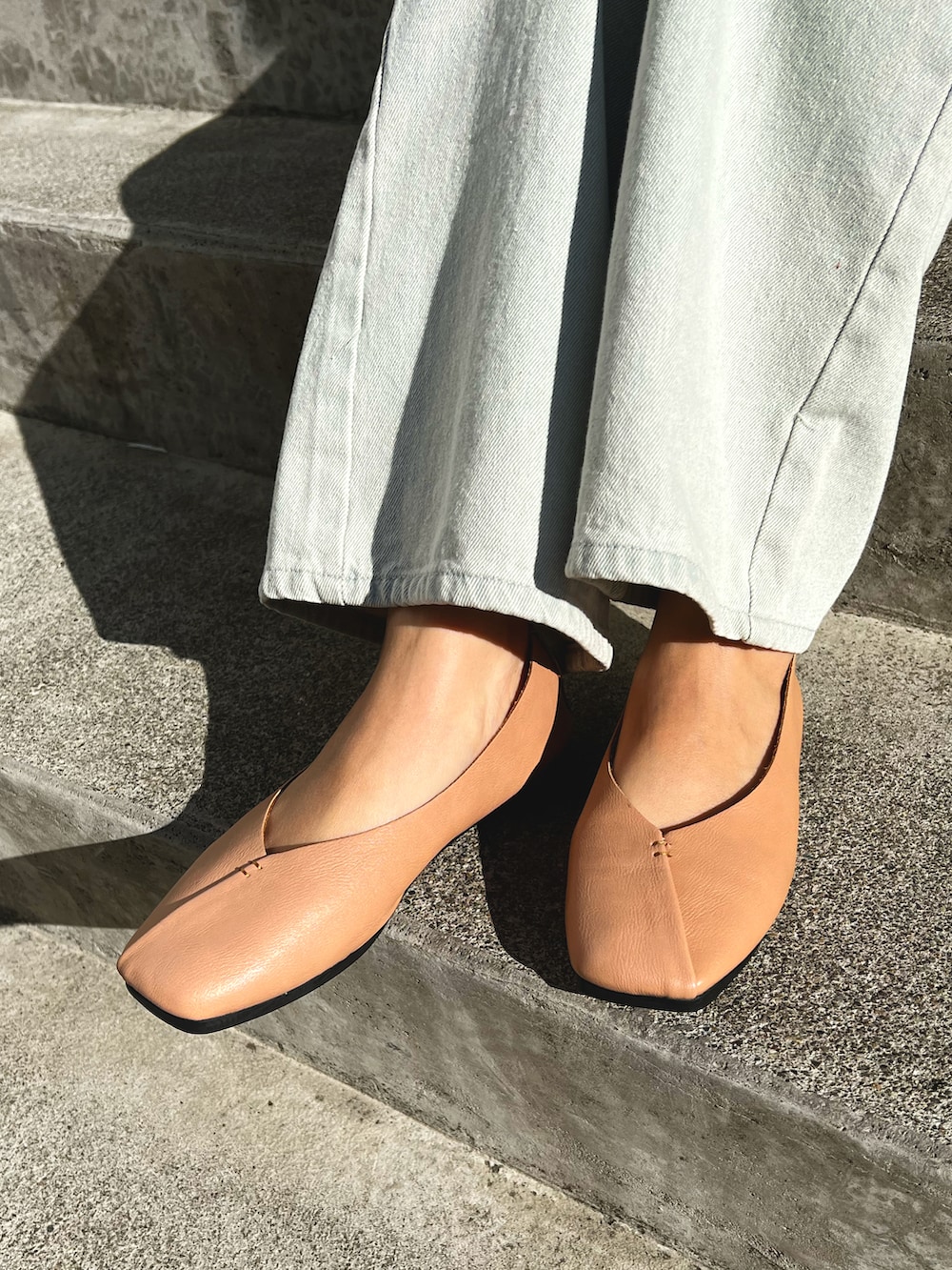 ブラウン系のパンプス、ホワイト系のスカートを着用したレディースの春コーディネートの3枚目の写真