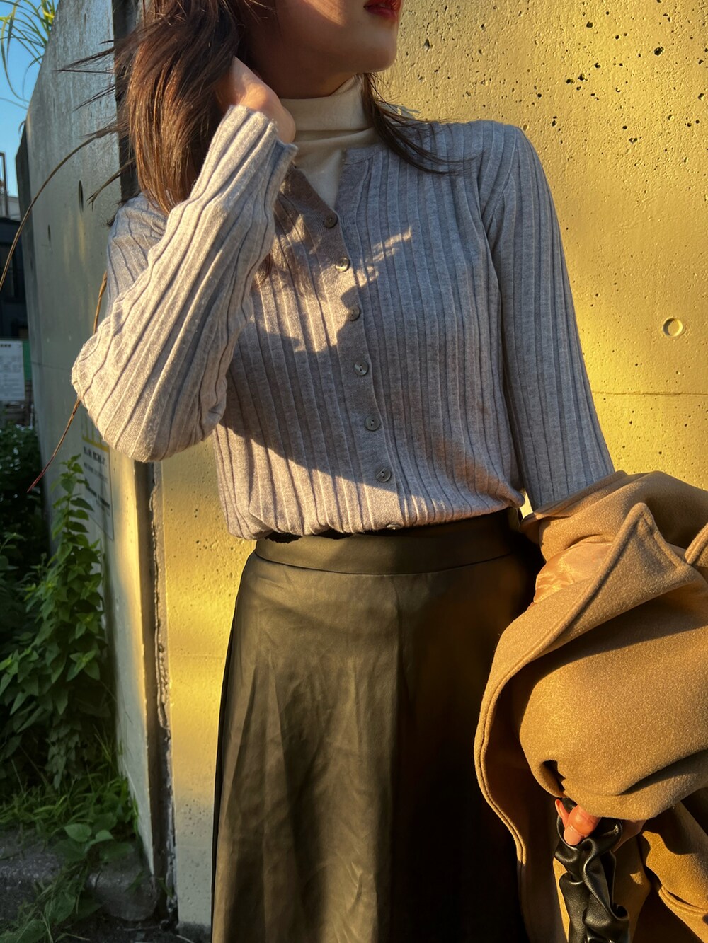 ブラック系のスカート、ベージュ系のブーツ、グレー系のカーディガン/ボレロを着用したレディースの秋コーディネートの2枚目の写真