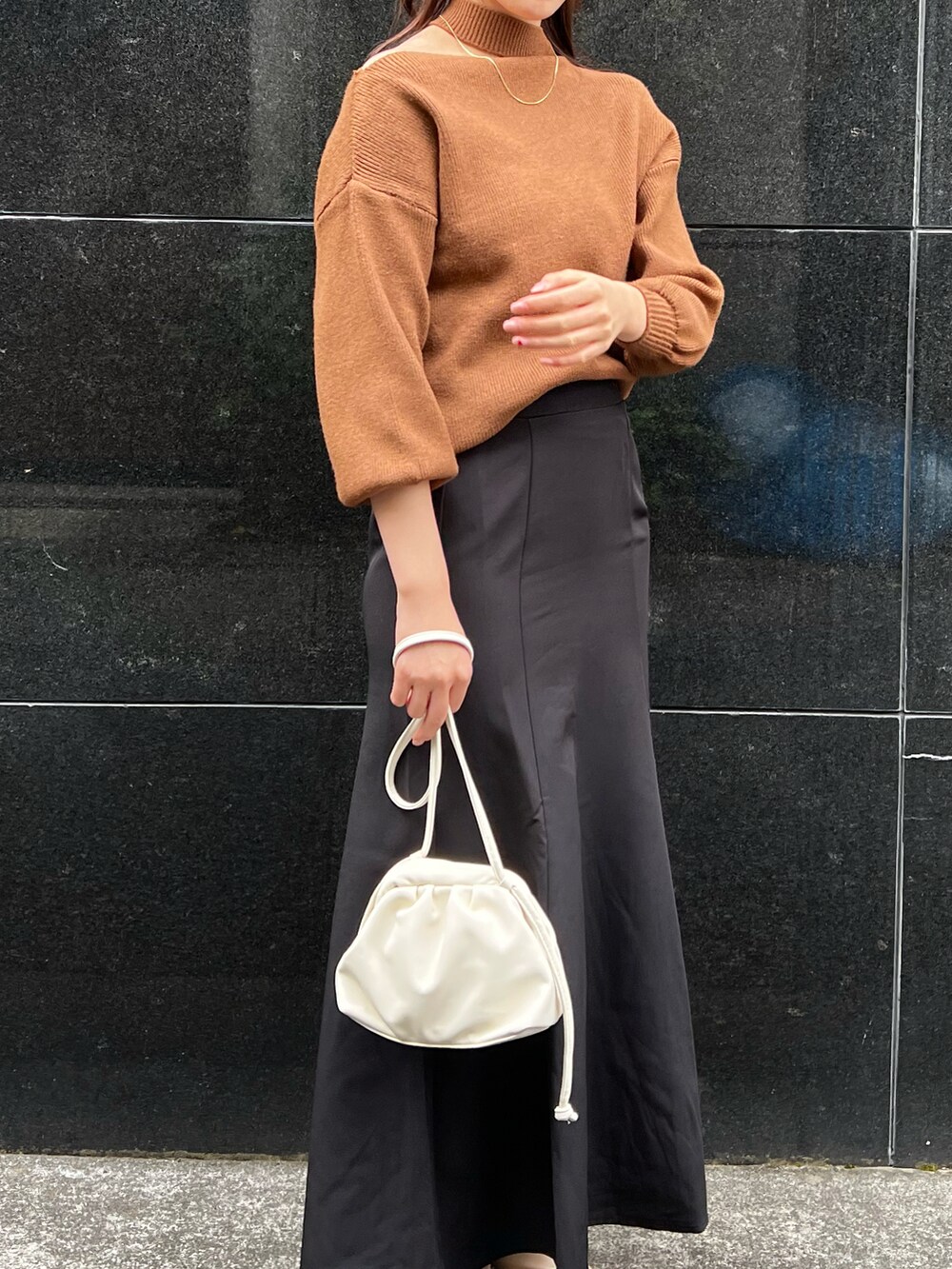 ブラウン系のニット/セーターを着用したレディースの冬コーディネートの3枚目の写真