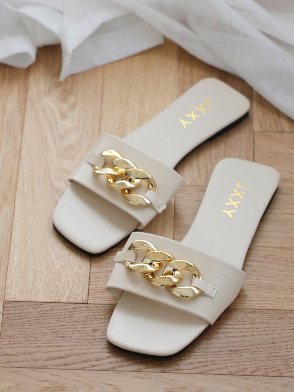 イエロー系のハンドバッグ、ブラック系のシャツワンピース、ホワイト系のサンダルを着用したレディースの春コーディネートの2枚目の写真