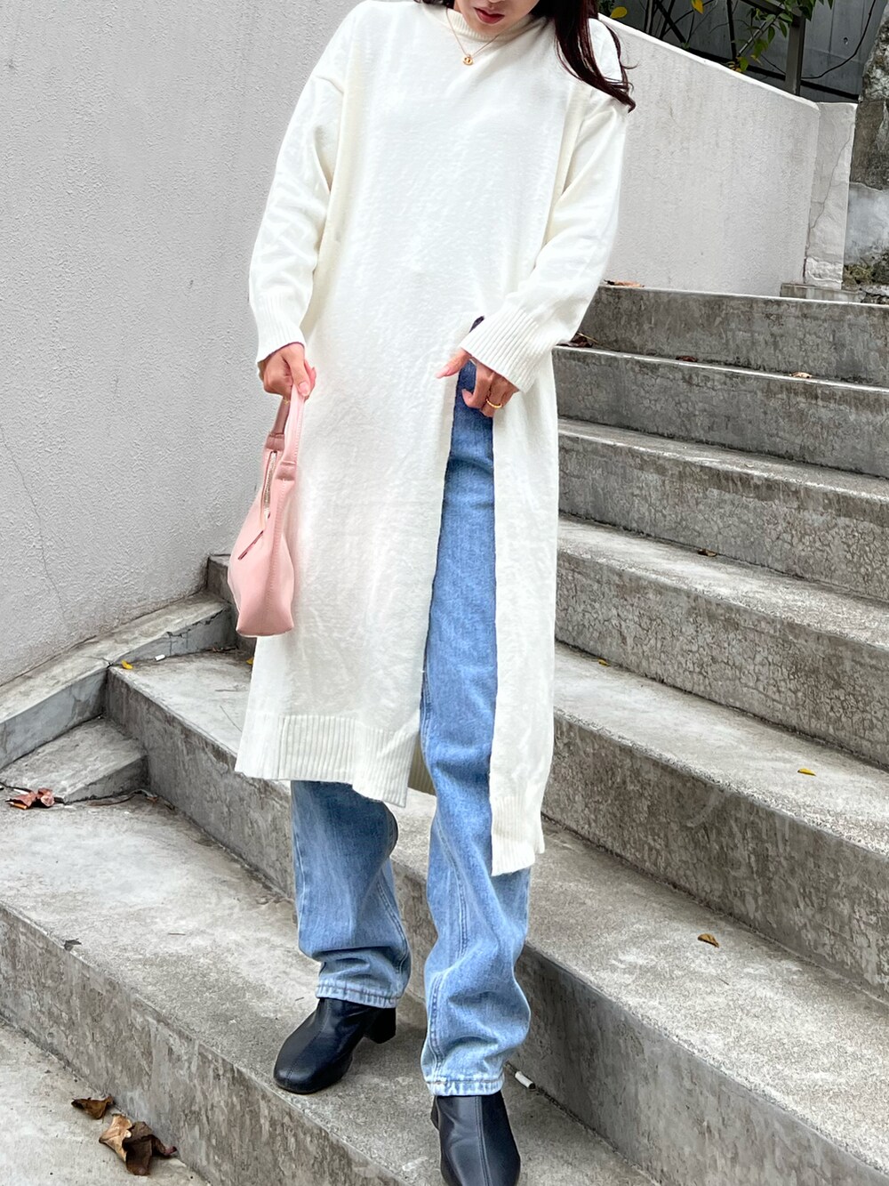 ホワイト系のワンピース、ピンク系のハンドバッグを着用したレディースの秋コーディネートの5枚目の写真