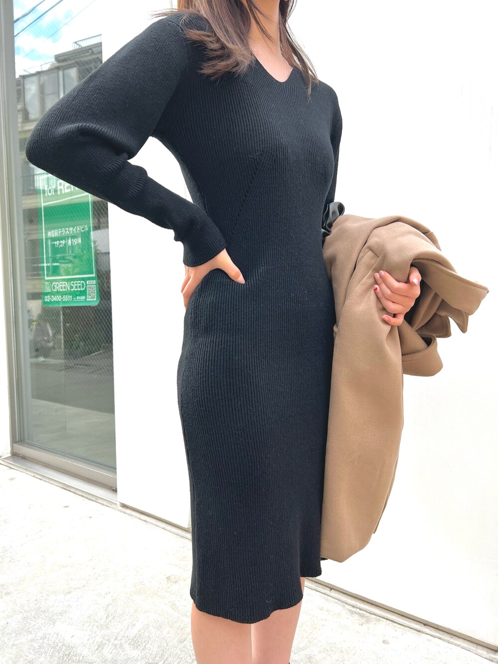 ブラック系のハンドバッグ、ブラック系のワンピース、ブラック系のブーツを着用したレディースの秋コーディネートの3枚目の写真