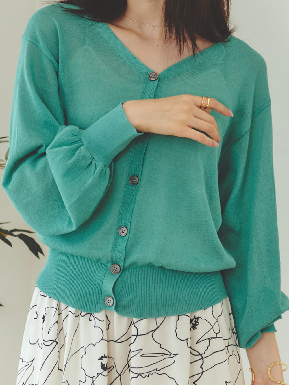 ホワイト系のスカート、グリーン系のカーディガン/ボレロ、ホワイト系のサンダルを着用したレディースの春コーディネートの2枚目の写真