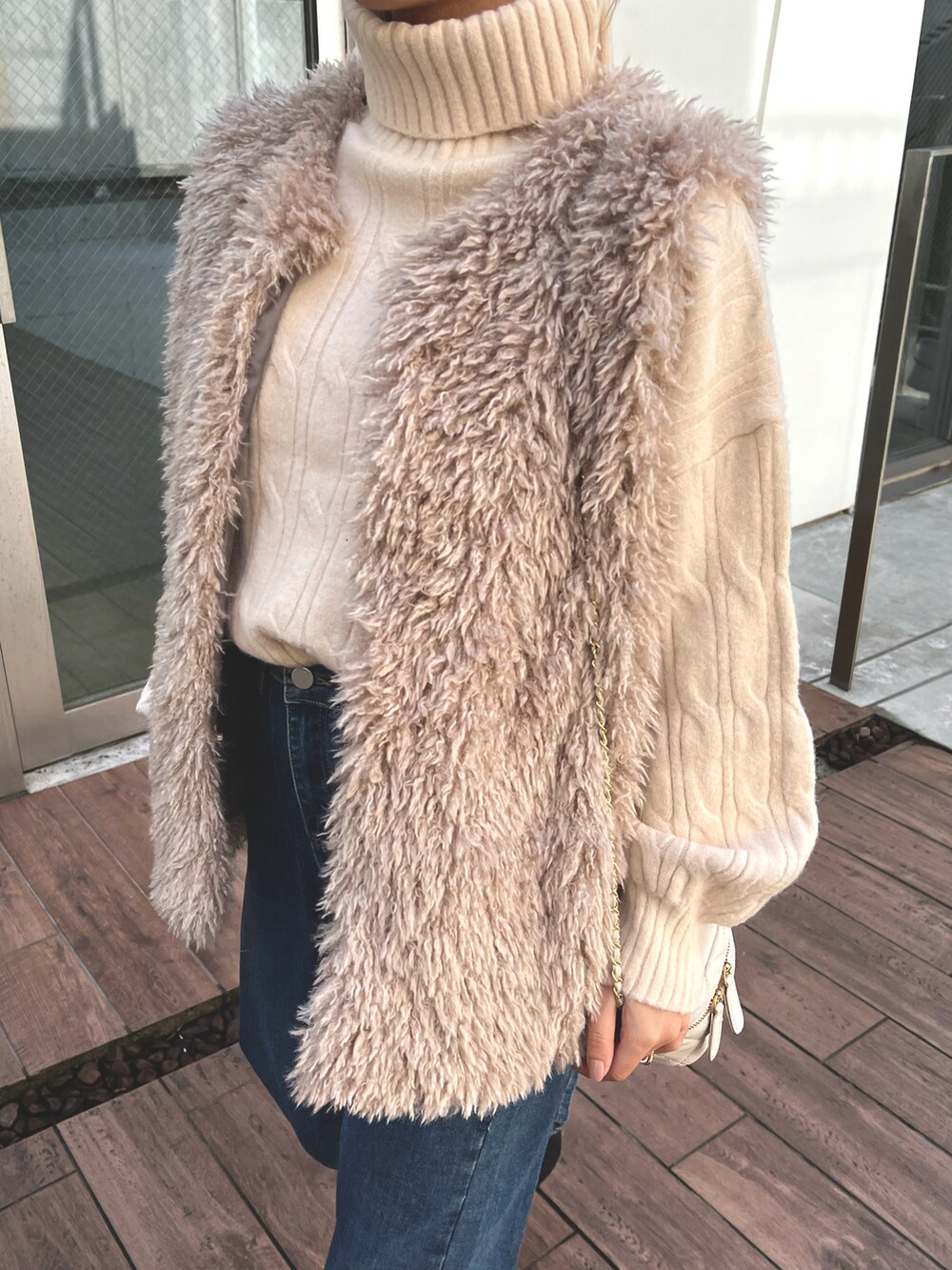 ホワイト系のベスト、ベージュ系のベストを着用したレディースの春コーディネートの3枚目の写真