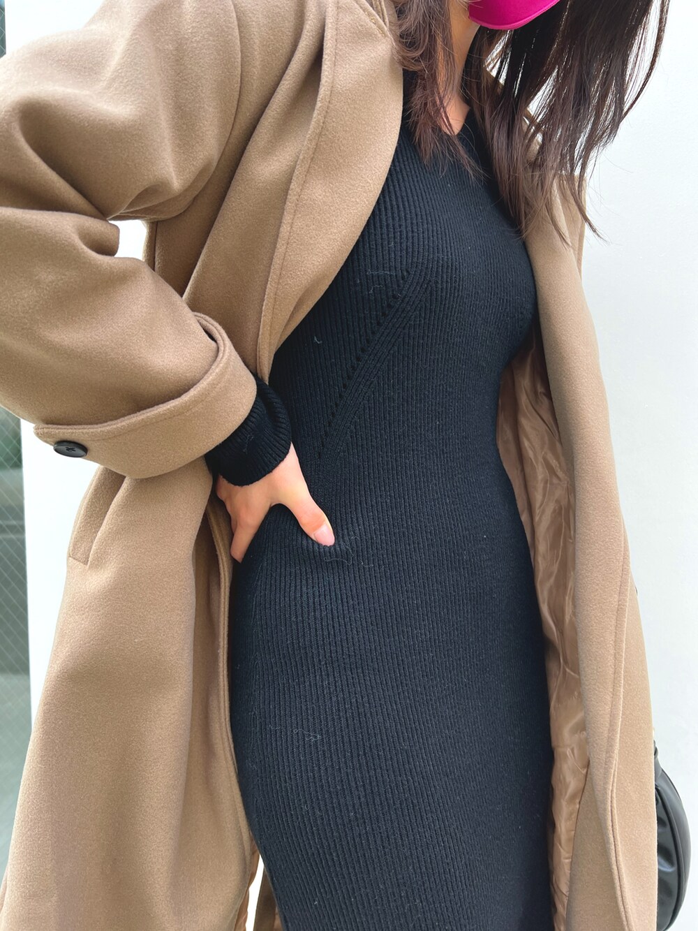 ブラック系のハンドバッグ、ブラック系のワンピース、ブラック系のブーツを着用したレディースの秋コーディネートの2枚目の写真