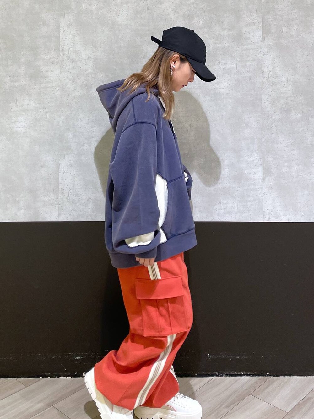 ホワイト系のスニーカー、オレンジ系のその他パンツ、ブルー系のパーカーを着用したレディースの秋コーディネートの2枚目の写真