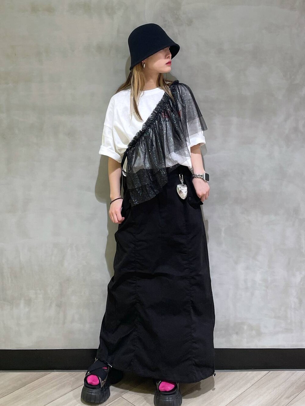 その他のスニーカー、ブラック系のスカート、ホワイト系のTシャツ/カットソーを着用したレディースの春コーディネートの4枚目の写真