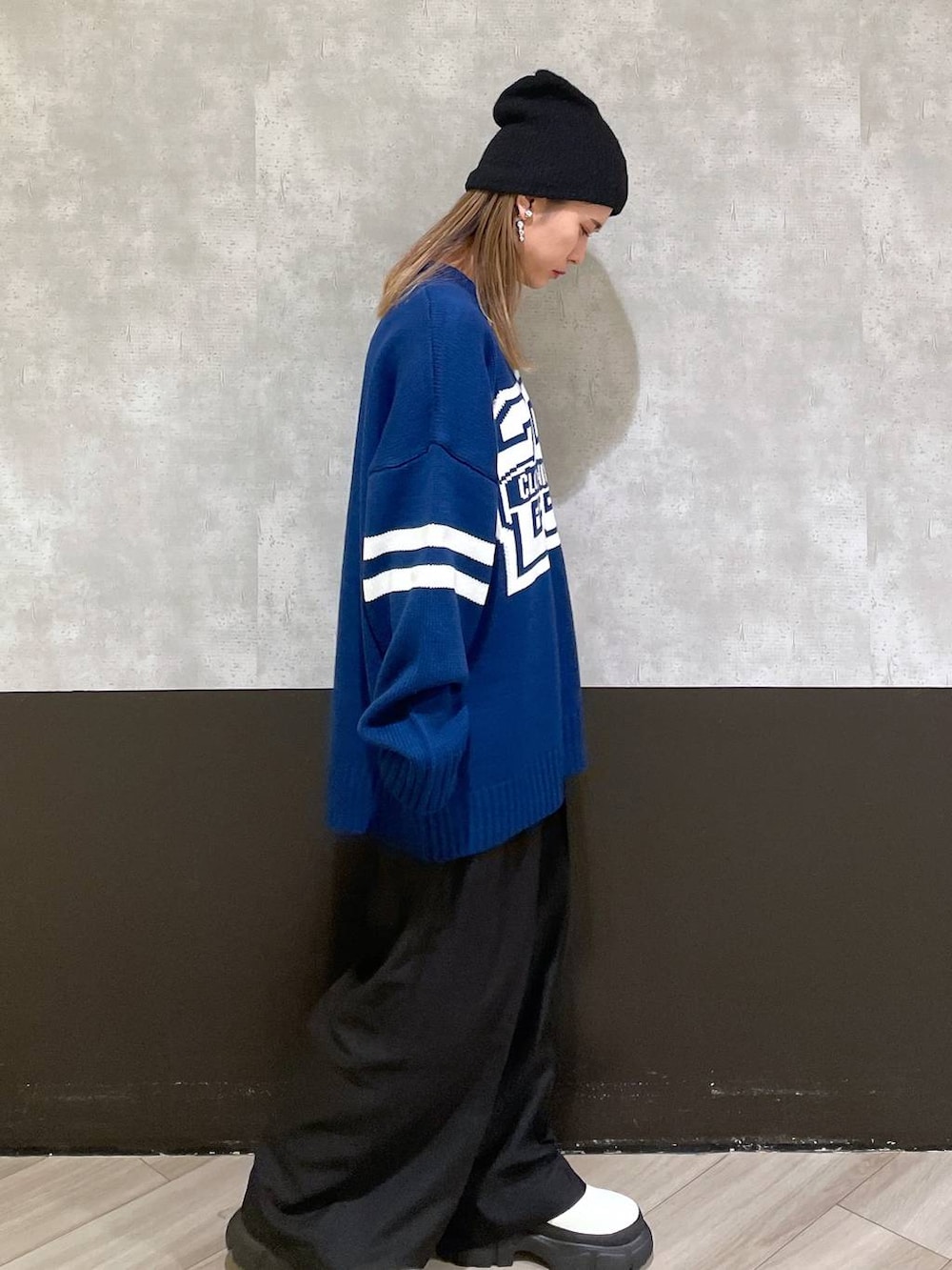 ホワイト系のブーツ、ブラック系のスラックス、ブルー系のニット/セーターを着用したレディースの秋コーディネートの2枚目の写真