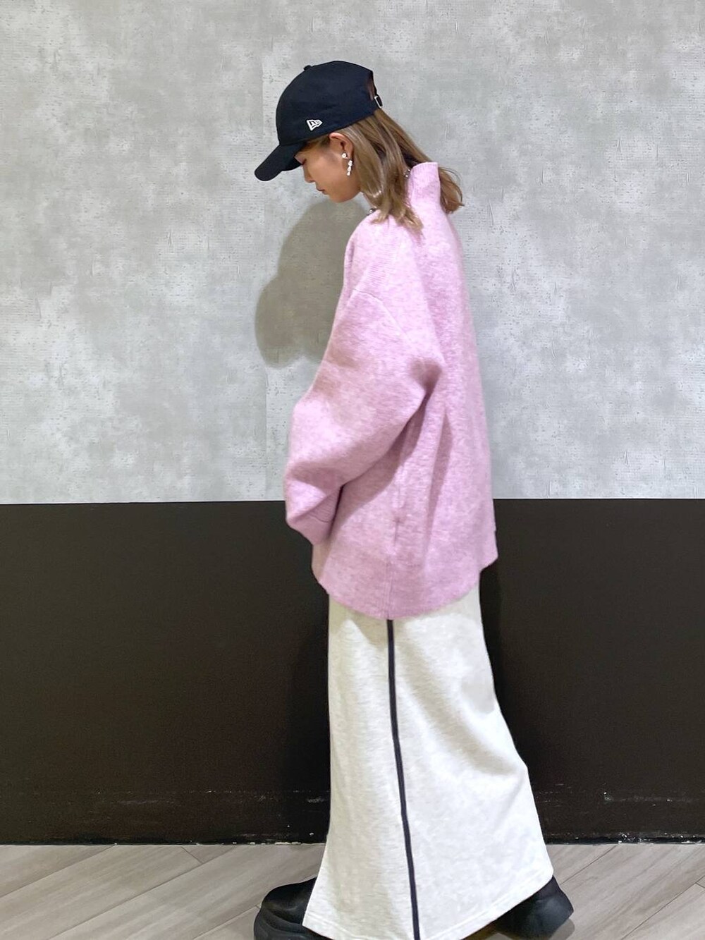 ブラック系のブーツ、レッド系のニット/セーター、ベージュ系のスカートを着用したレディースの秋コーディネートの2枚目の写真