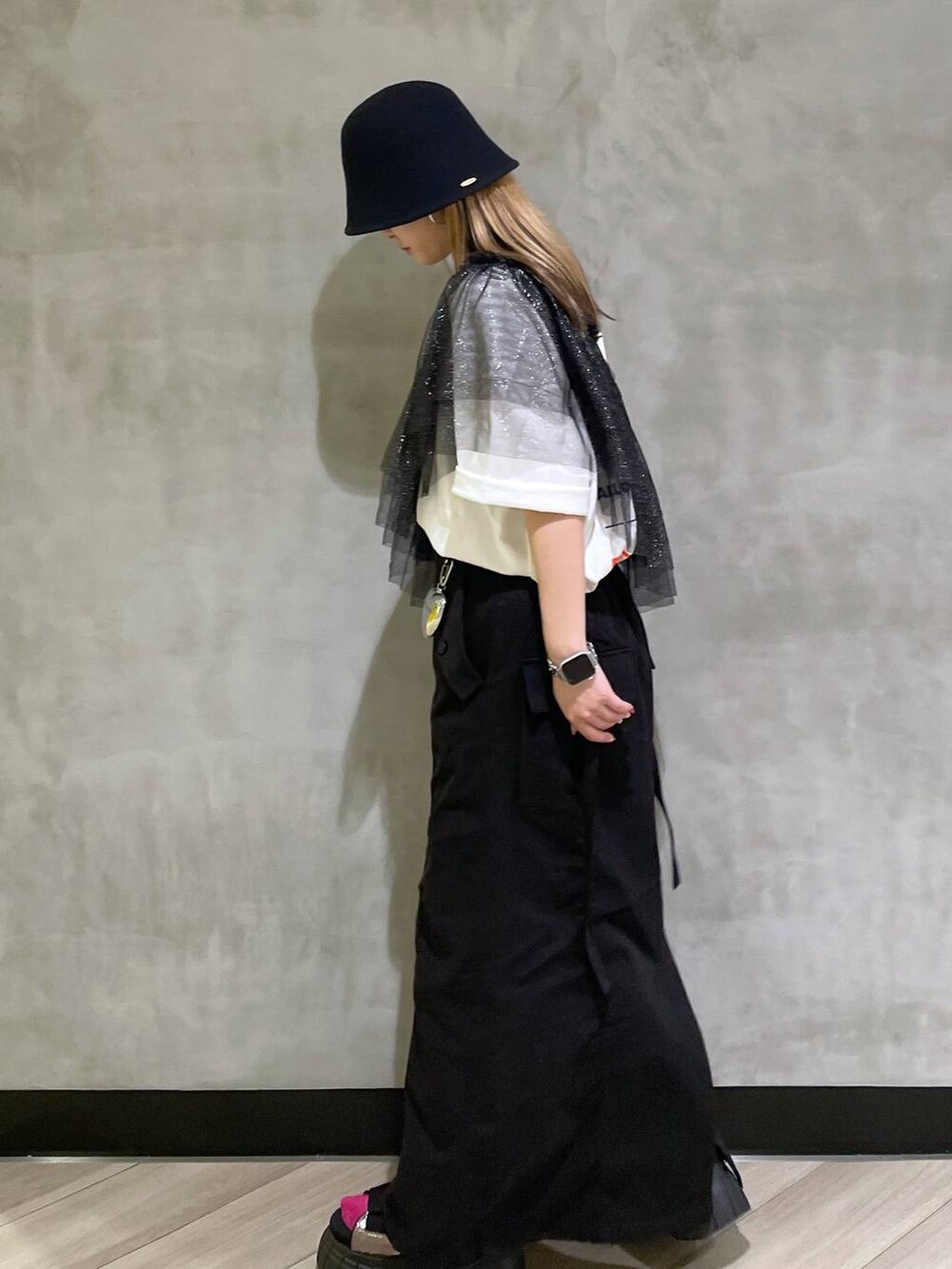 その他のスニーカー、ブラック系のスカート、ホワイト系のTシャツ/カットソーを着用したレディースの春コーディネートの2枚目の写真