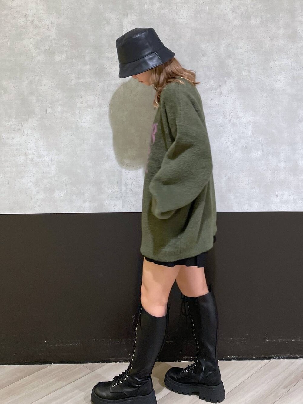 ブラック系のブーツ、グリーン系のニット/セーター、ブラック系のその他パンツを着用したレディースの秋コーディネートの2枚目の写真