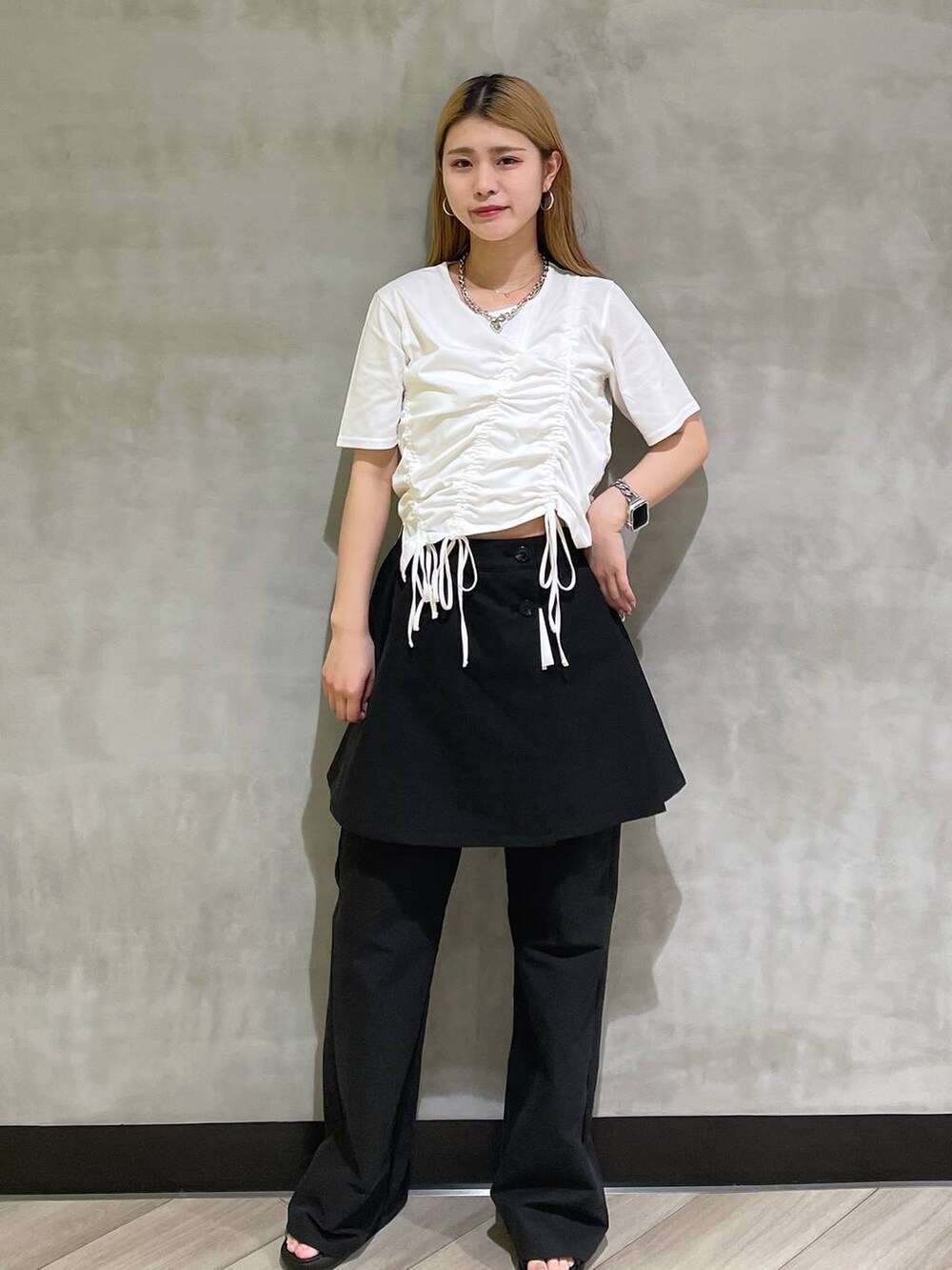 ブラック系のサンダル、ホワイト系のTシャツ/カットソー、ブラック系のチノパンツを着用したレディースの夏コーディネートの4枚目の写真