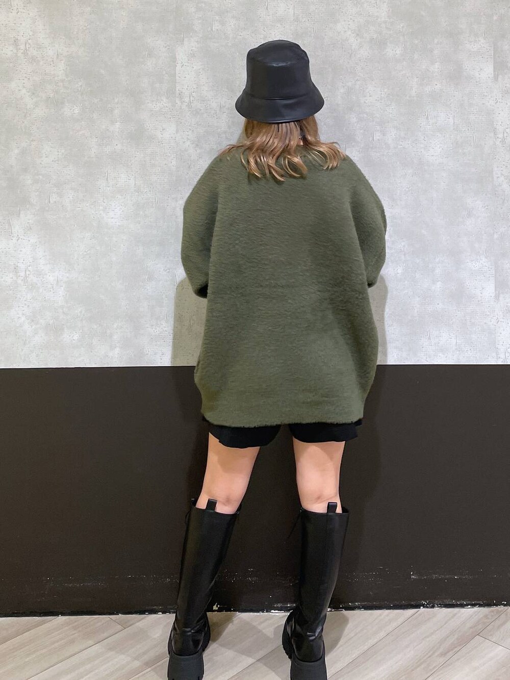 ブラック系のブーツ、グリーン系のニット/セーター、ブラック系のその他パンツを着用したレディースの秋コーディネートの3枚目の写真