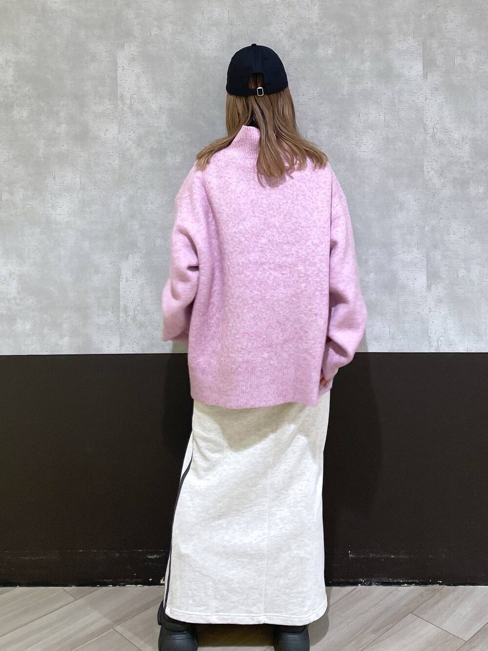 ブラック系のブーツ、レッド系のニット/セーター、ベージュ系のスカートを着用したレディースの秋コーディネートの3枚目の写真