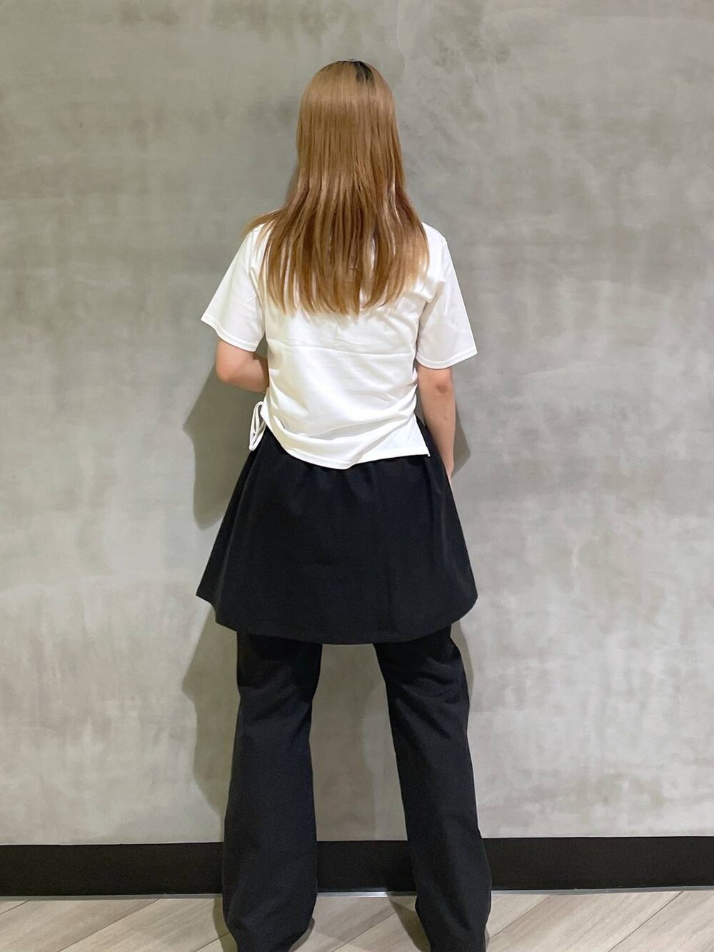 ブラック系のサンダル、ホワイト系のTシャツ/カットソー、ブラック系のチノパンツを着用したレディースの夏コーディネートの3枚目の写真