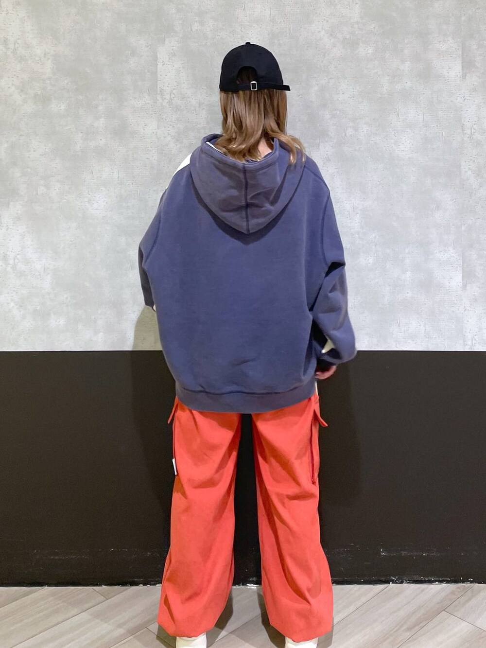 ホワイト系のスニーカー、オレンジ系のその他パンツ、ブルー系のパーカーを着用したレディースの秋コーディネートの3枚目の写真