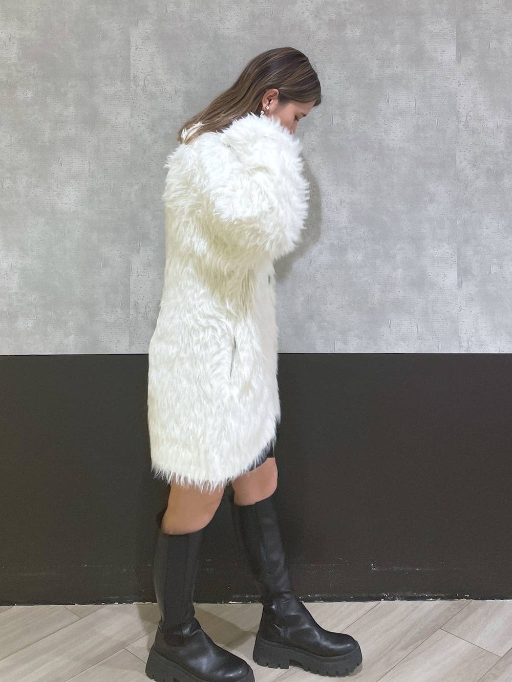 ホワイト系のカーディガン/ボレロ、ブラック系のブーツ、ブラック系のスカートを着用したレディースの秋コーディネートの2枚目の写真